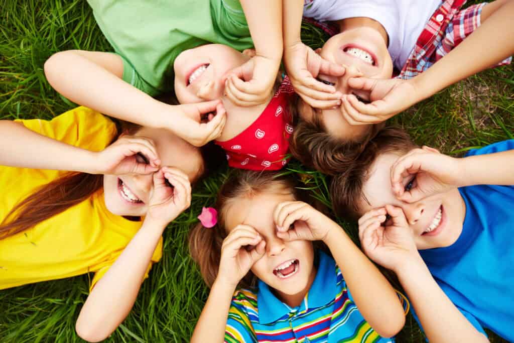 Cursos de inglés con profesor nativo children playing grass scaled 1